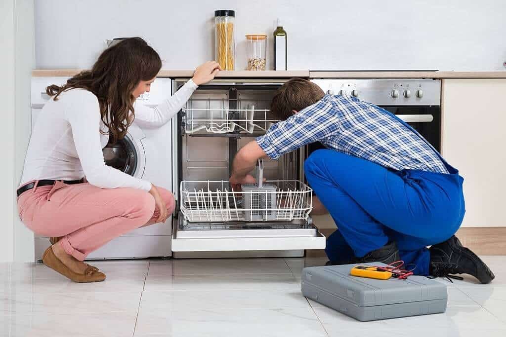 Appliance repair technician fixing the dishwasher