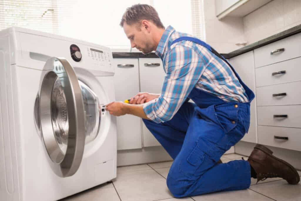 Appliance repair technician fixing the refrigerator compressor