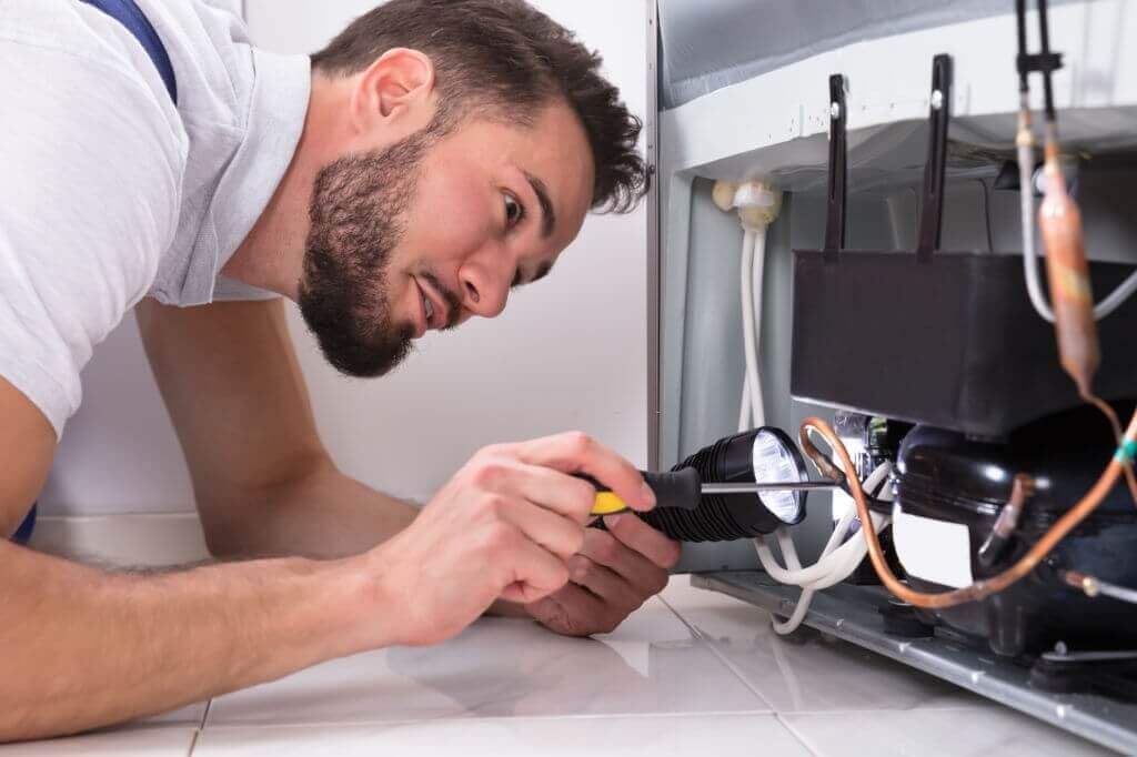 Appliance repair technician fixing the door latch on the washer
